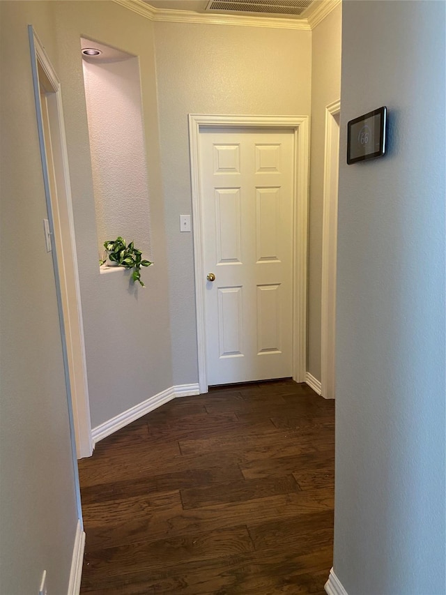 corridor with dark hardwood / wood-style floors and ornamental molding