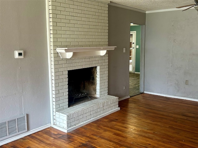 unfurnished living room featuring dark hardwood / wood-style flooring, ornamental molding, a textured ceiling, ceiling fan, and a fireplace