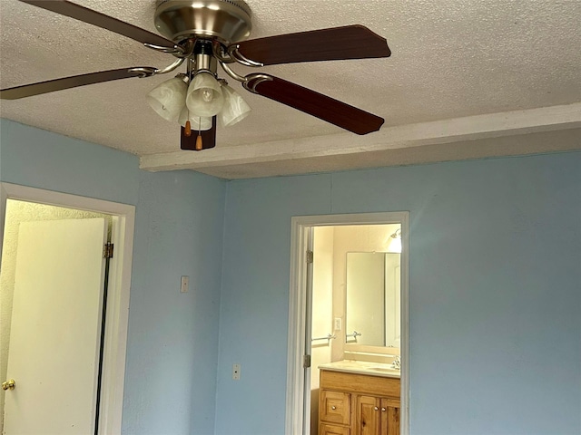 unfurnished bedroom with ensuite bathroom, ceiling fan, and a textured ceiling