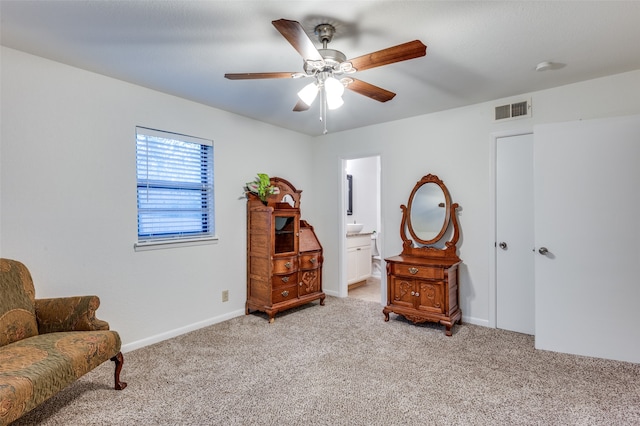 living area featuring light carpet and ceiling fan