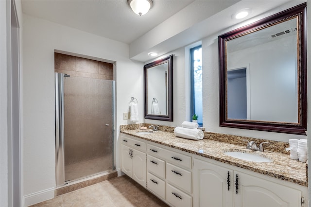 bathroom featuring tile patterned flooring, vanity, and a shower with door