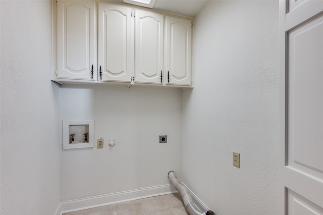 washroom with cabinets, washer hookup, hookup for an electric dryer, gas dryer hookup, and light tile patterned flooring