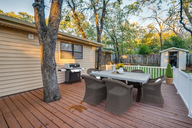 wooden terrace featuring a grill and a storage unit