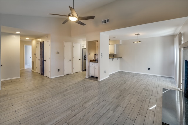 unfurnished living room featuring light hardwood / wood-style floors, ceiling fan, and lofted ceiling