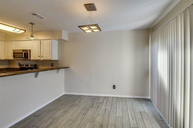 kitchen with black range with electric stovetop, white cabinetry, kitchen peninsula, light hardwood / wood-style floors, and decorative light fixtures