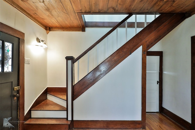 stairs featuring hardwood / wood-style floors and wooden ceiling