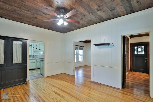 spare room with light wood-type flooring, wooden walls, ceiling fan, and wooden ceiling