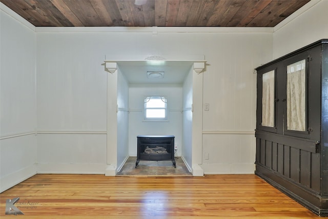 entryway with wood-type flooring, a wood stove, wood walls, and wood ceiling
