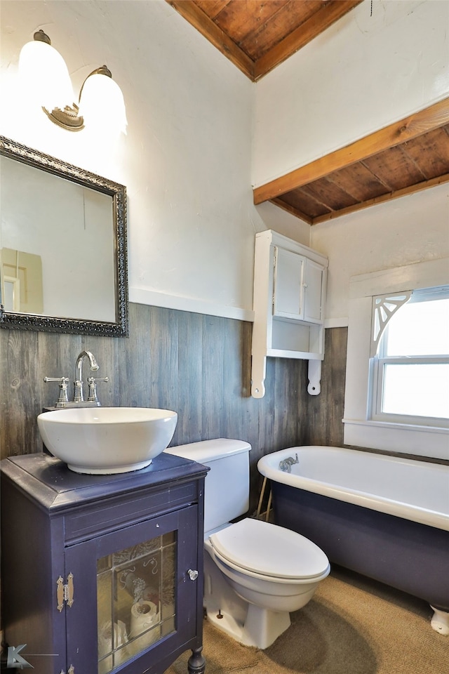 bathroom featuring a bathing tub, toilet, wooden walls, vanity, and wood ceiling
