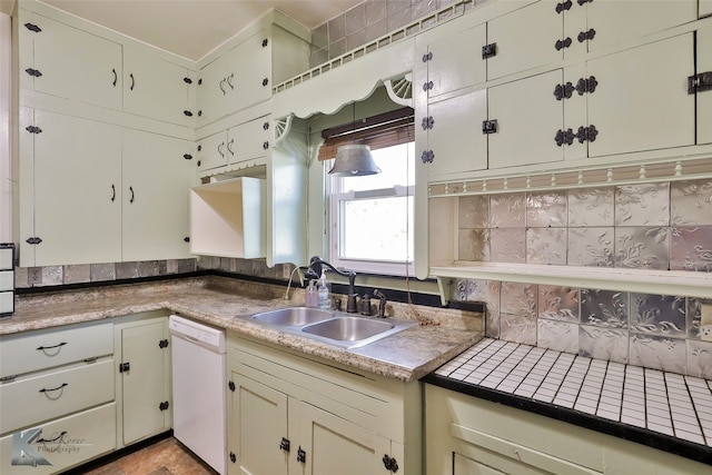 kitchen featuring backsplash, dishwasher, and sink