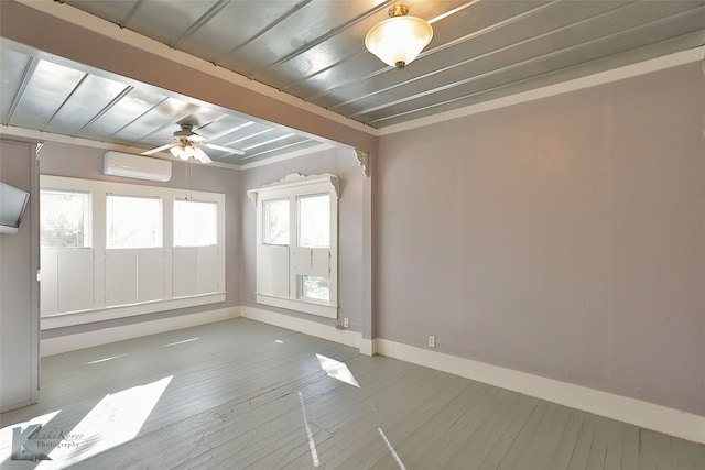 empty room featuring ceiling fan, light hardwood / wood-style floors, and a wall mounted AC
