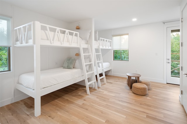 bedroom with hardwood / wood-style floors and multiple windows