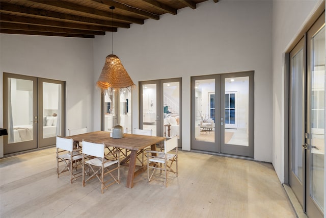 unfurnished dining area featuring french doors, beamed ceiling, wood ceiling, and plenty of natural light