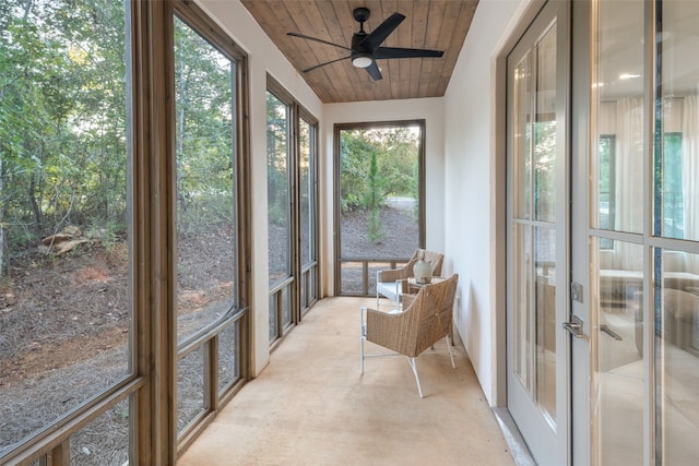 unfurnished sunroom featuring a wealth of natural light, french doors, ceiling fan, and wooden ceiling