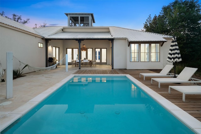 23502 Kate Ln, Arp, TX 75750 - back of house at dusk with a deck, stucco siding, french doors, and metal roof