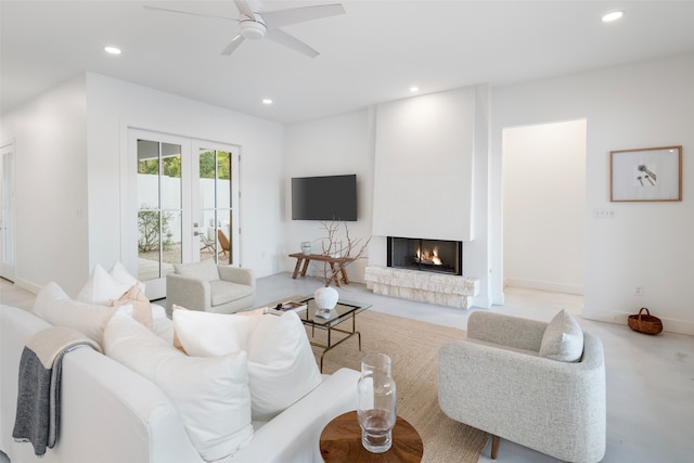 living room with ceiling fan and a fireplace