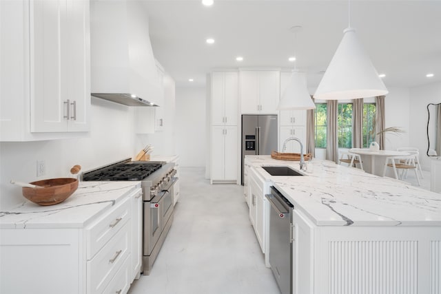 kitchen featuring white cabinets, appliances with stainless steel finishes, premium range hood, and sink