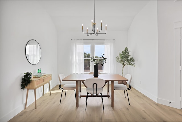 dining space featuring a chandelier, light hardwood / wood-style floors, and lofted ceiling