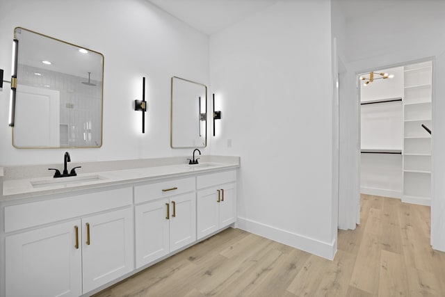 bathroom with a chandelier, wood-type flooring, vanity, and walk in shower