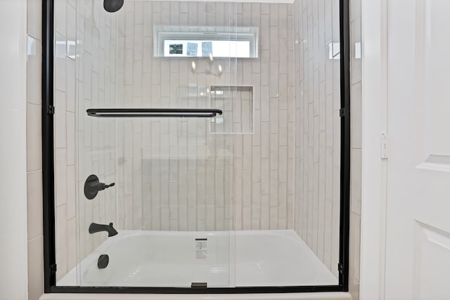 bathroom with shower / bath combination with glass door