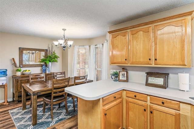 kitchen with dark hardwood / wood-style flooring, hanging light fixtures, a textured ceiling, and a notable chandelier