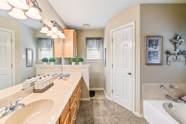 bathroom with a tub to relax in, plenty of natural light, vanity, and a textured ceiling