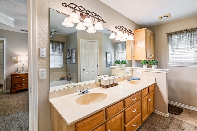 bathroom with plenty of natural light, ceiling fan, a textured ceiling, and vanity