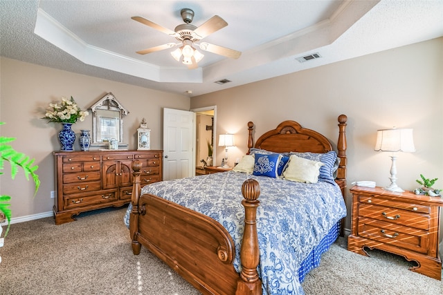 bedroom with light colored carpet, a raised ceiling, and ceiling fan