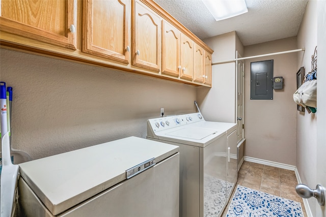 washroom featuring cabinets, electric panel, washer and dryer, light tile patterned floors, and a textured ceiling