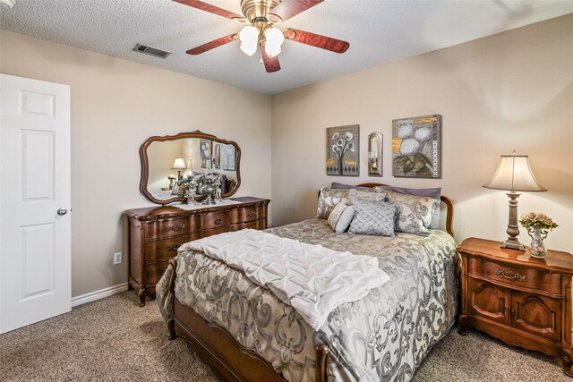 carpeted bedroom with ceiling fan and a textured ceiling