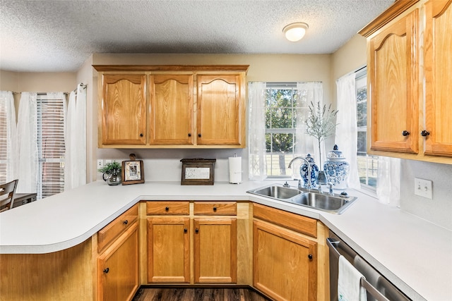 kitchen with dishwasher, sink, dark hardwood / wood-style flooring, kitchen peninsula, and a textured ceiling