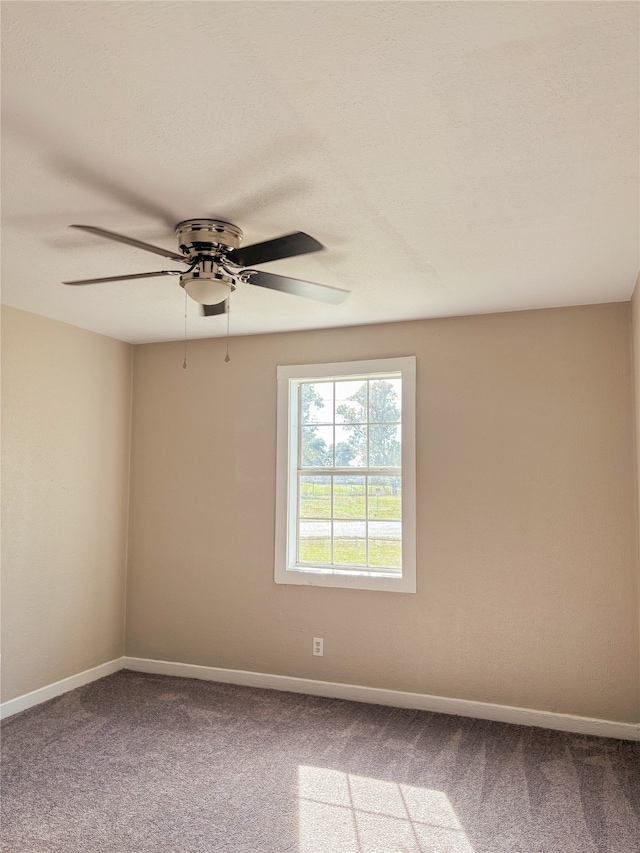 carpeted spare room with ceiling fan