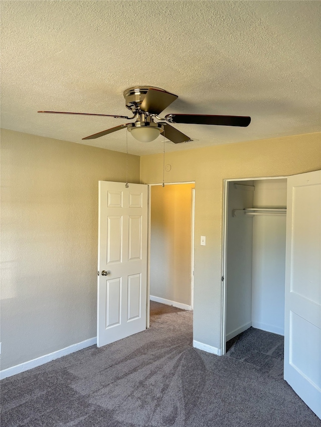 unfurnished bedroom featuring dark colored carpet, ceiling fan, a textured ceiling, and a closet