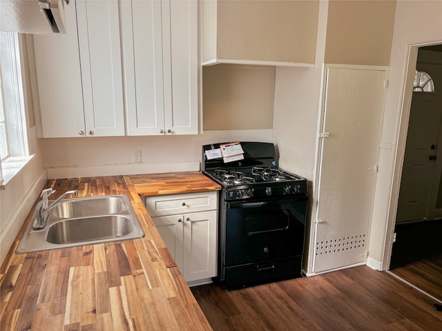 kitchen with black gas range, sink, dark hardwood / wood-style floors, butcher block countertops, and white cabinets