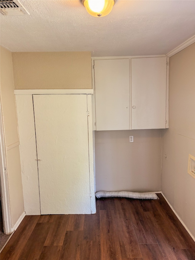 laundry room featuring washer hookup, dark hardwood / wood-style flooring, cabinets, and a textured ceiling