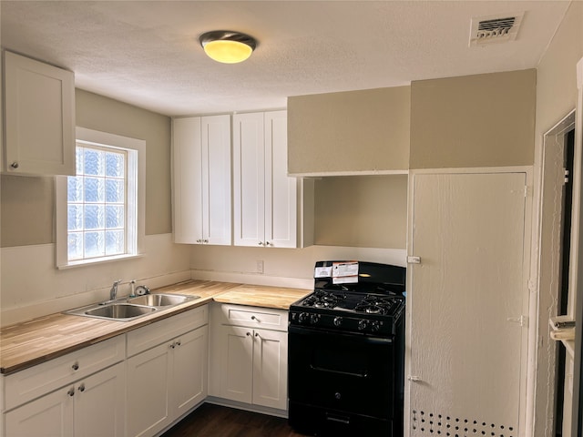 kitchen with wood counters, sink, a textured ceiling, white cabinetry, and black range with gas cooktop