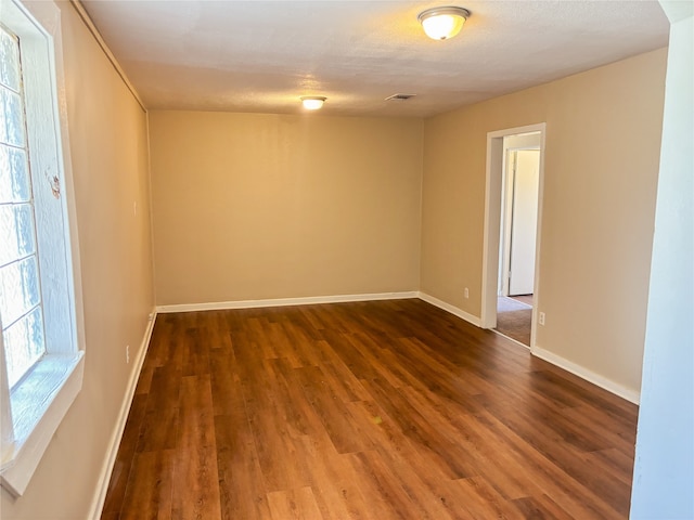 unfurnished room with dark hardwood / wood-style flooring