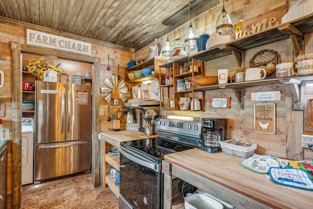 kitchen featuring wood walls, wooden ceiling, hanging light fixtures, appliances with stainless steel finishes, and washer / dryer