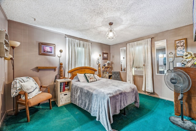 bedroom featuring carpet floors, a textured ceiling, and wooden walls