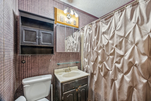 bathroom with vanity, a textured ceiling, crown molding, tile walls, and toilet