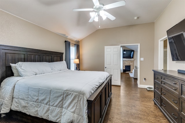 bedroom featuring hardwood / wood-style flooring, ceiling fan, lofted ceiling, and a fireplace