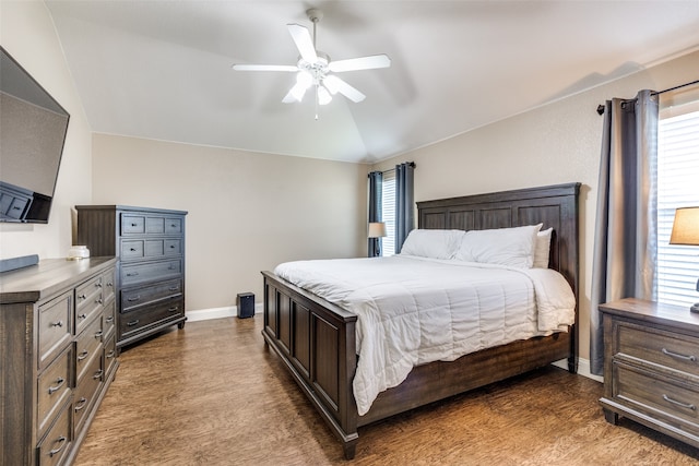 bedroom with ceiling fan, lofted ceiling, and dark wood-type flooring