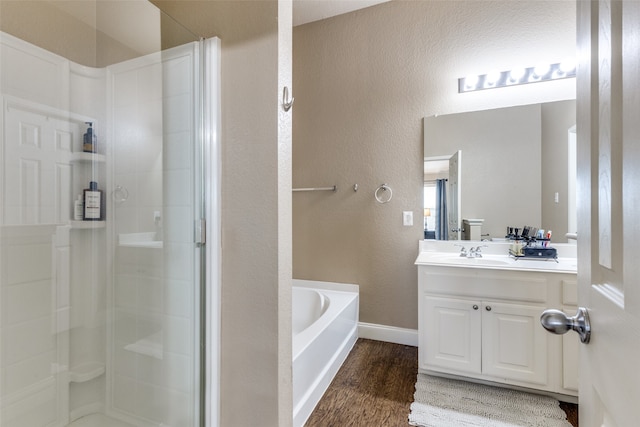 bathroom with hardwood / wood-style floors, vanity, and independent shower and bath