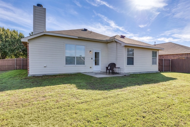 back of property with a patio area and a yard