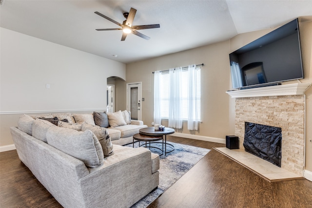 living room featuring ceiling fan, dark hardwood / wood-style flooring, a fireplace, and vaulted ceiling