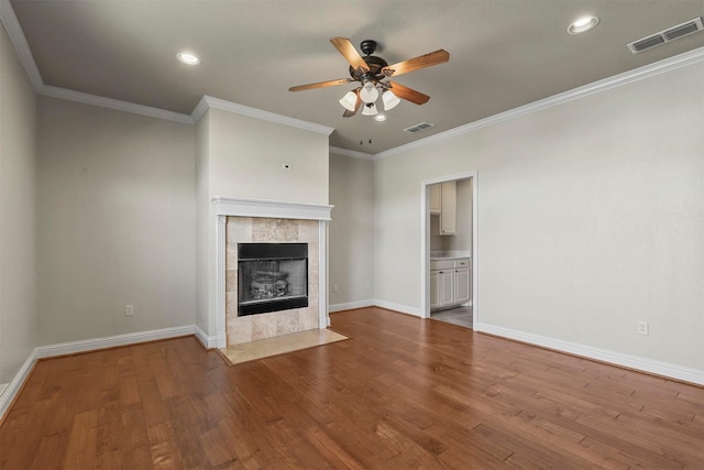 unfurnished living room with ceiling fan, ornamental molding, a fireplace, and hardwood / wood-style floors