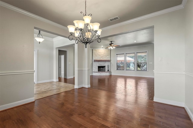 unfurnished living room with ornamental molding, ceiling fan with notable chandelier, a fireplace, and dark hardwood / wood-style flooring