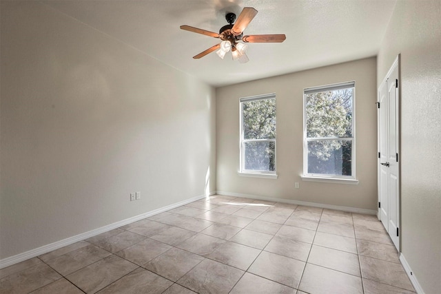 empty room featuring light tile patterned flooring and ceiling fan