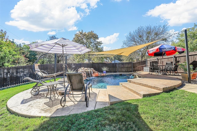 view of pool featuring pool water feature, a patio area, and a lawn