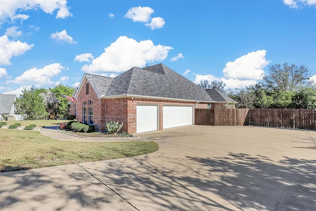 view of side of home with a garage and a lawn